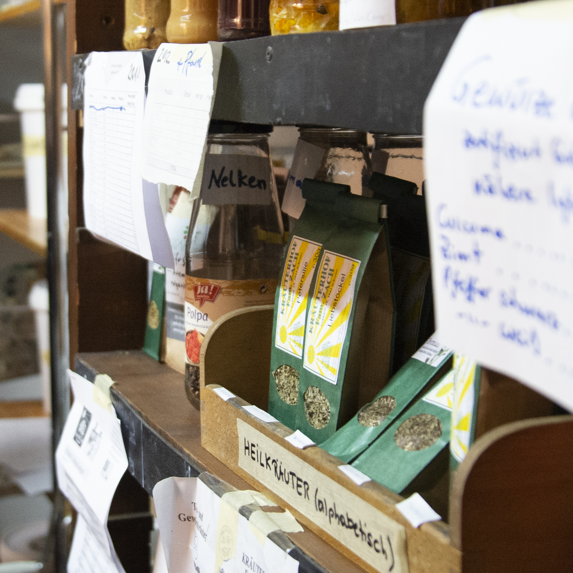 Ein Regal in einer foodcoop mit Heilkräutern und anderen Lebensmitteln