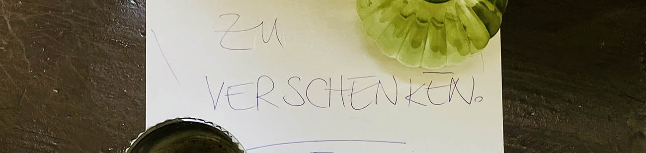 Glasvasen stehen auf einem Schild, auf. dem steht: Zu verschenken