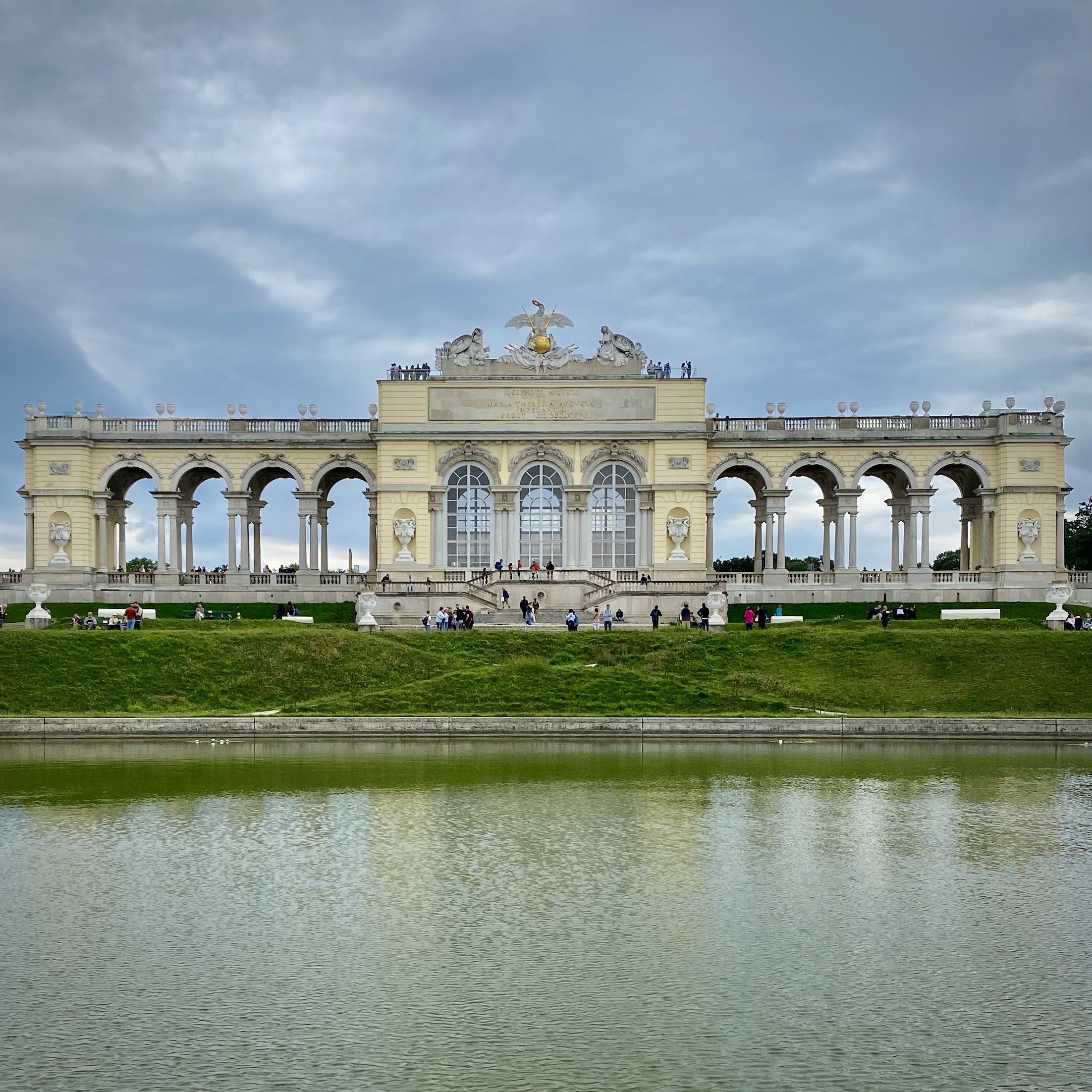 Die Gloriette, ein barockes Gebäude im Schlosspark von Schönbrunn in Wien, davor viele Menschen