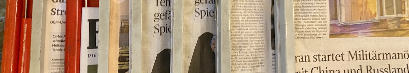 Ausschnitt von in einem Kaffeehaus ausgelegten Zeitungen