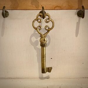 Ein verschnörkelter goldener Schlüssel an einem Haken