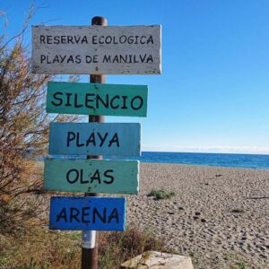Ein Schild an einem spanischen Strand mit den Aufschriften silencio, playa, olas, arena. Aufgenommen in Südspanien