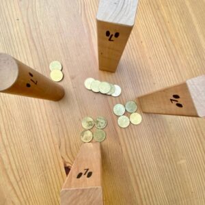 Die Holzklötze in der Endposition. Derobere hat die meisten Geldstücke vor sich liegen, die anderen viel weniger