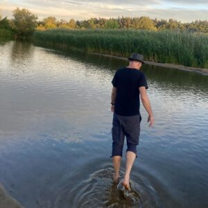 Ein Mann geht durch einen Fluss davon