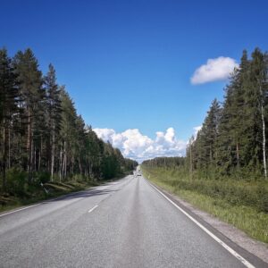 Eine schnurgerade lange Straße in Finnland, die durch Wälder führt